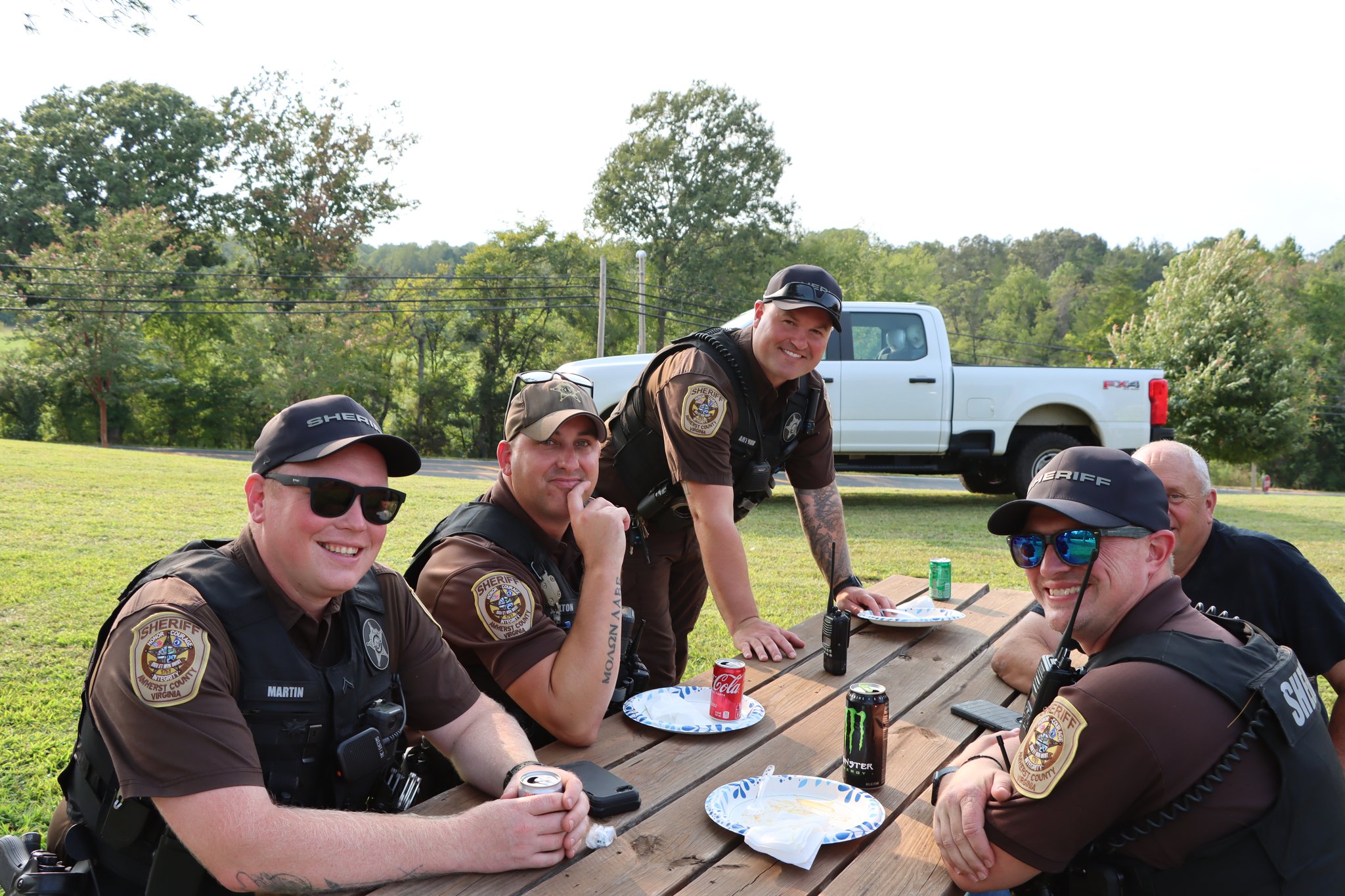 Amherst County sheriff's deputies eating alongside families at the Community Tailgate