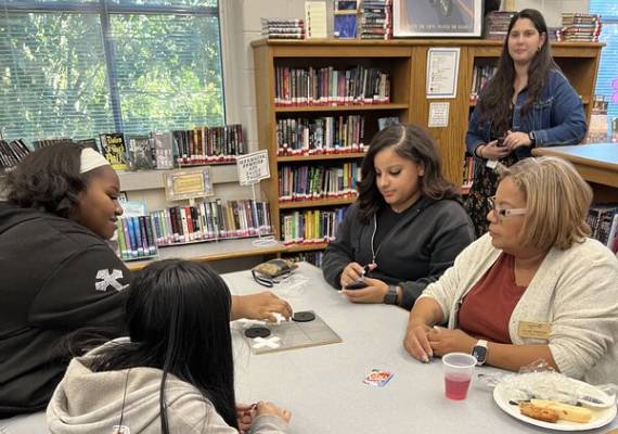 School board members playing card games with students