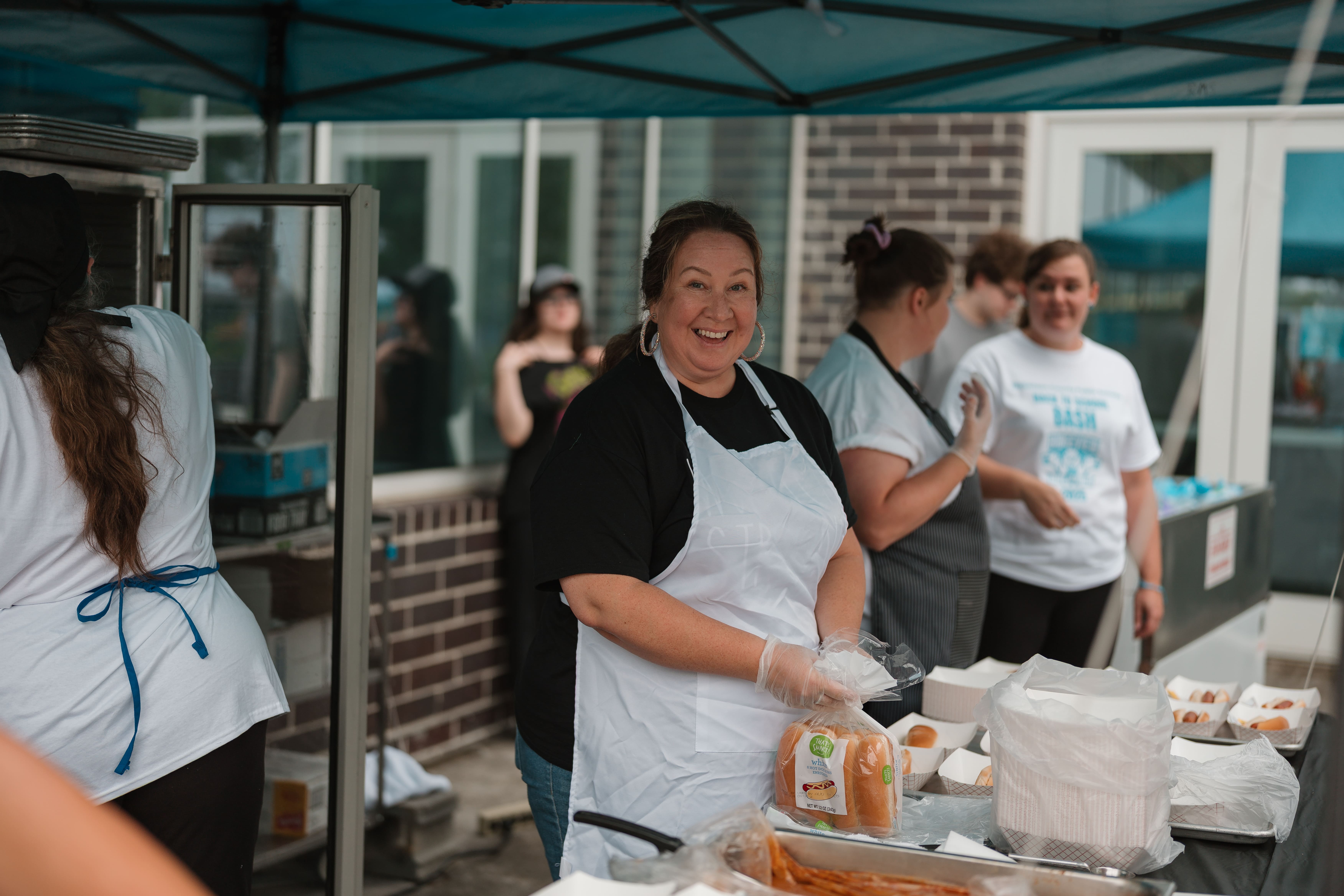Food service volunteer laughing while serving at the Dickenson County Back to School Bash