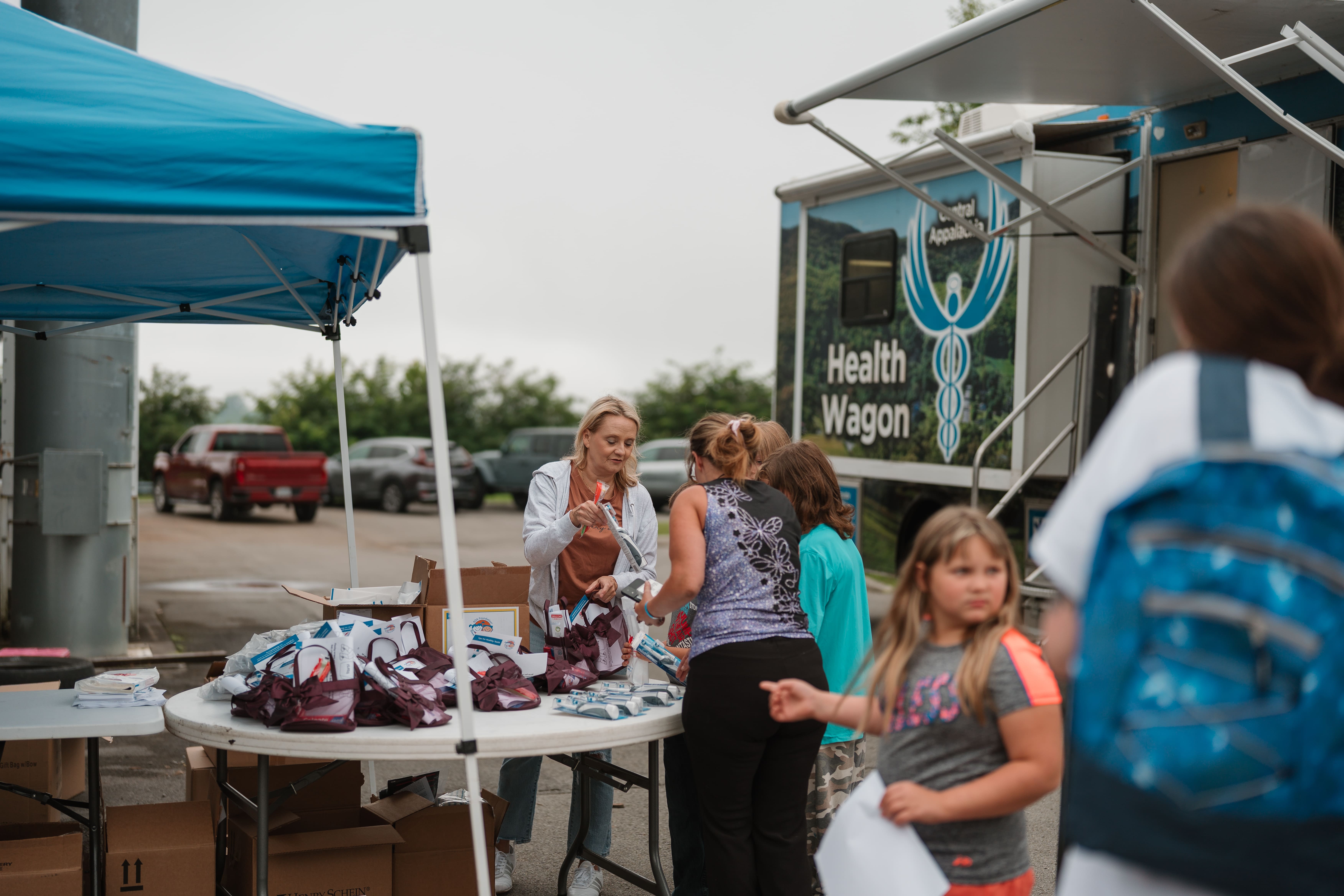 Health Wagon mobile clinic staff consulting with a family at the Back to School Bash