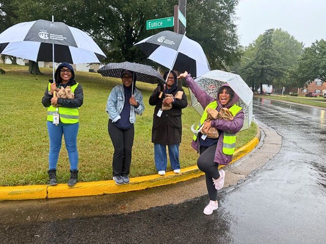 Tucker High School staff greeting students at a neighborhood bus stop pop-up