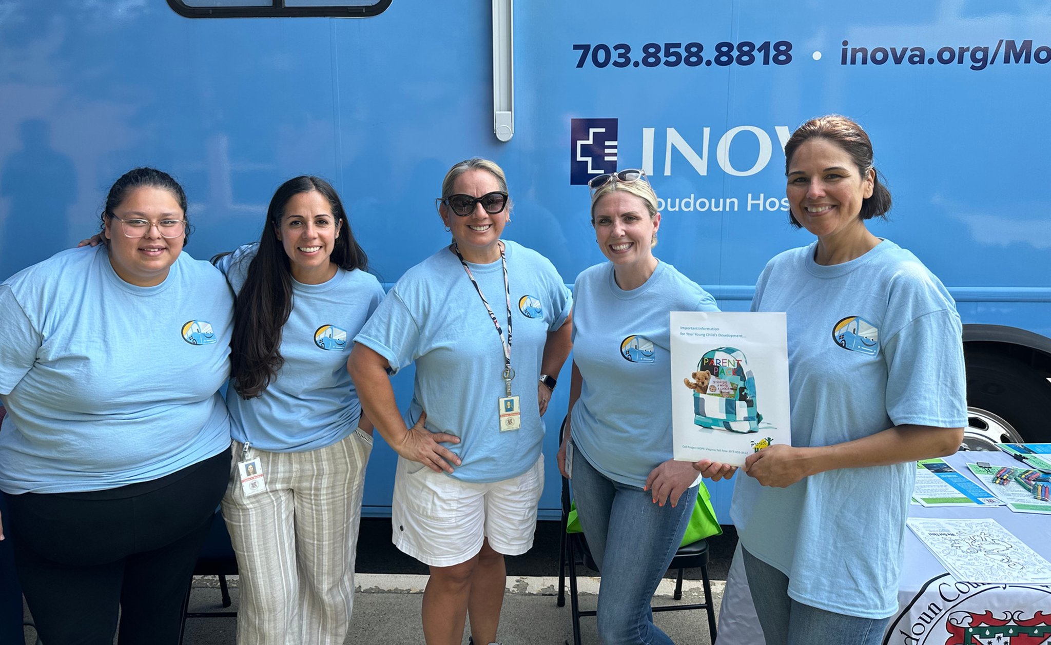 Five-person clinical team standing outside the Loudoun County mobile health clinic bus