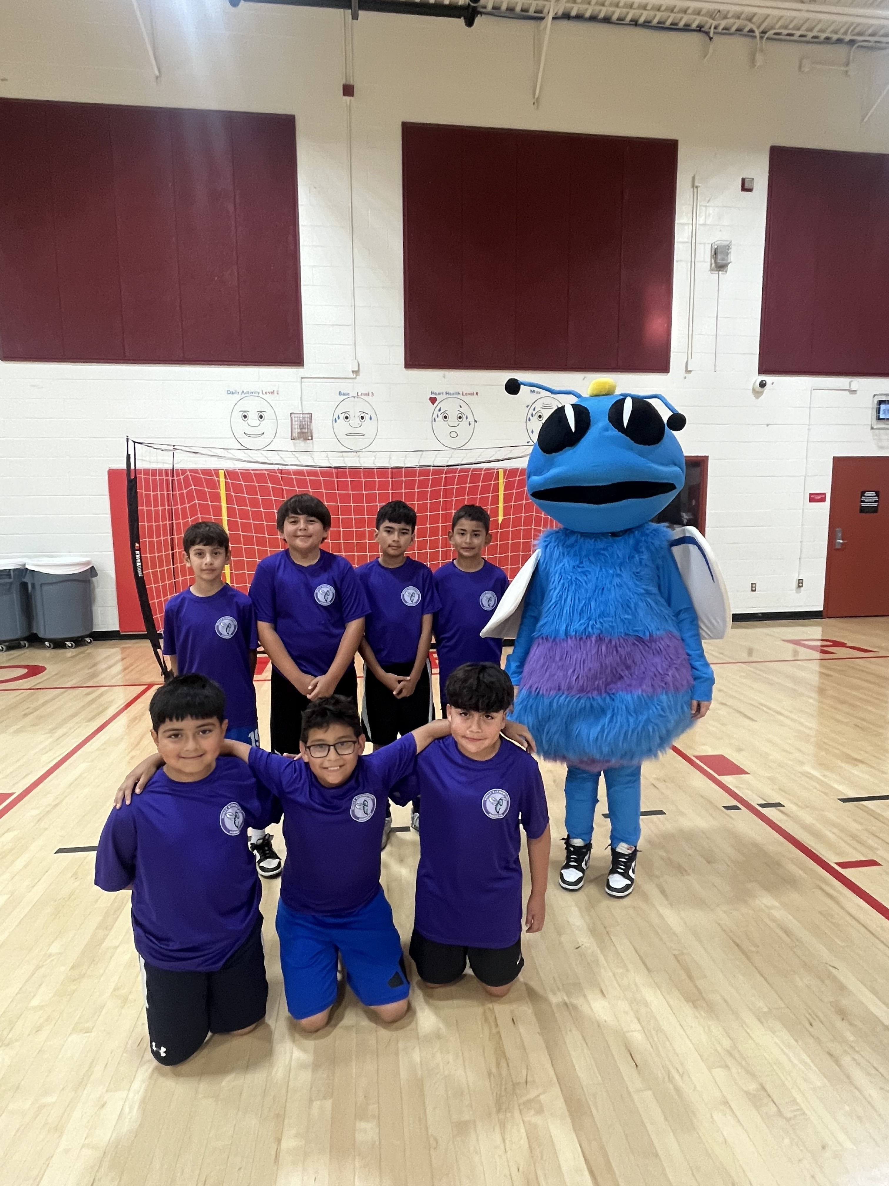 Sully Elementary futsal team in blue jerseys posing with school mascot