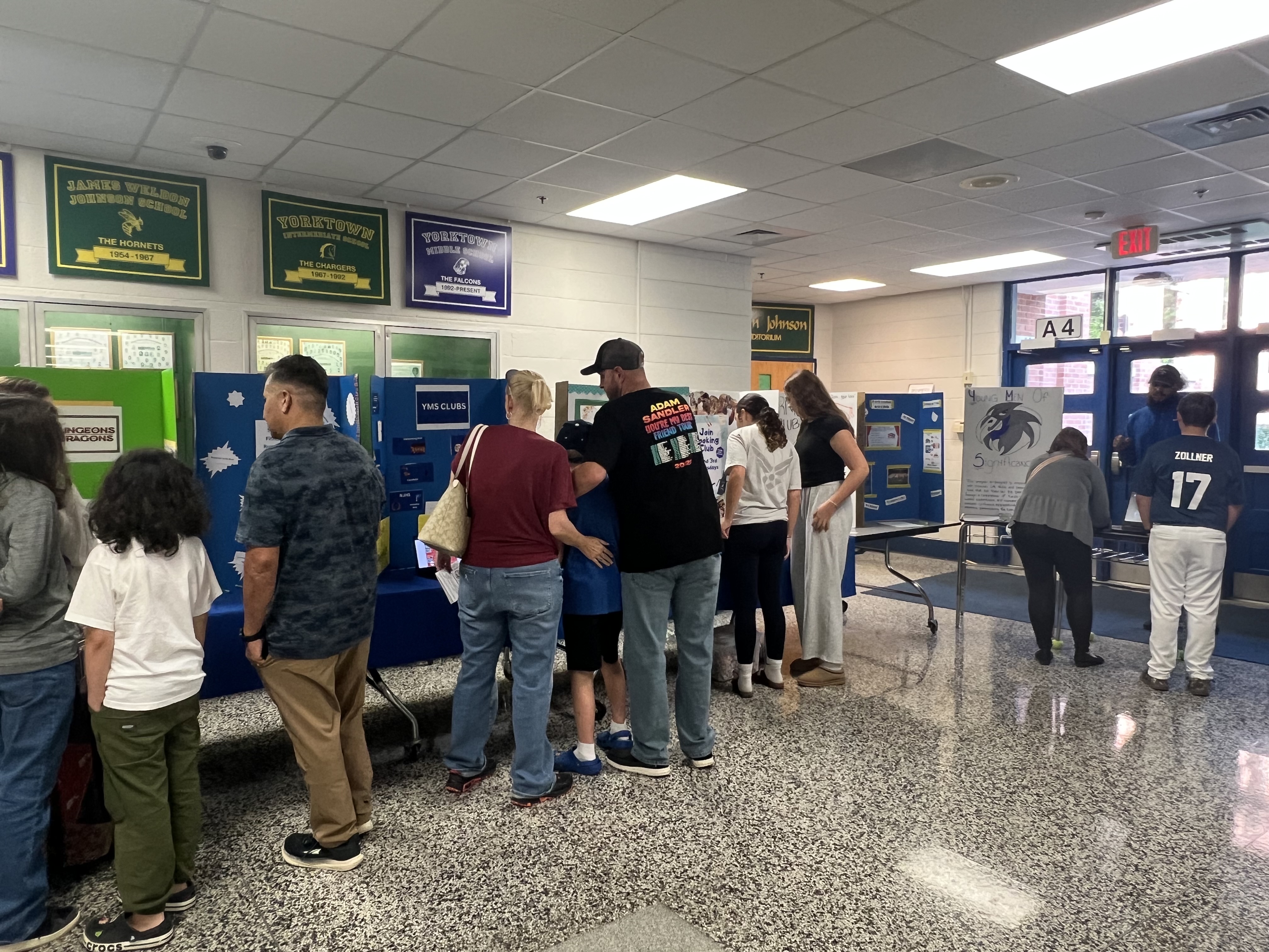 Families browsing student club sign-up tables at Yorktown Middle School family engagement night