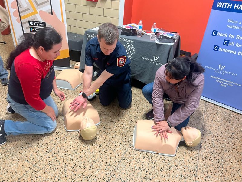Families participating in Hands2Hearts CPR training at an Arlington County Community Schools event