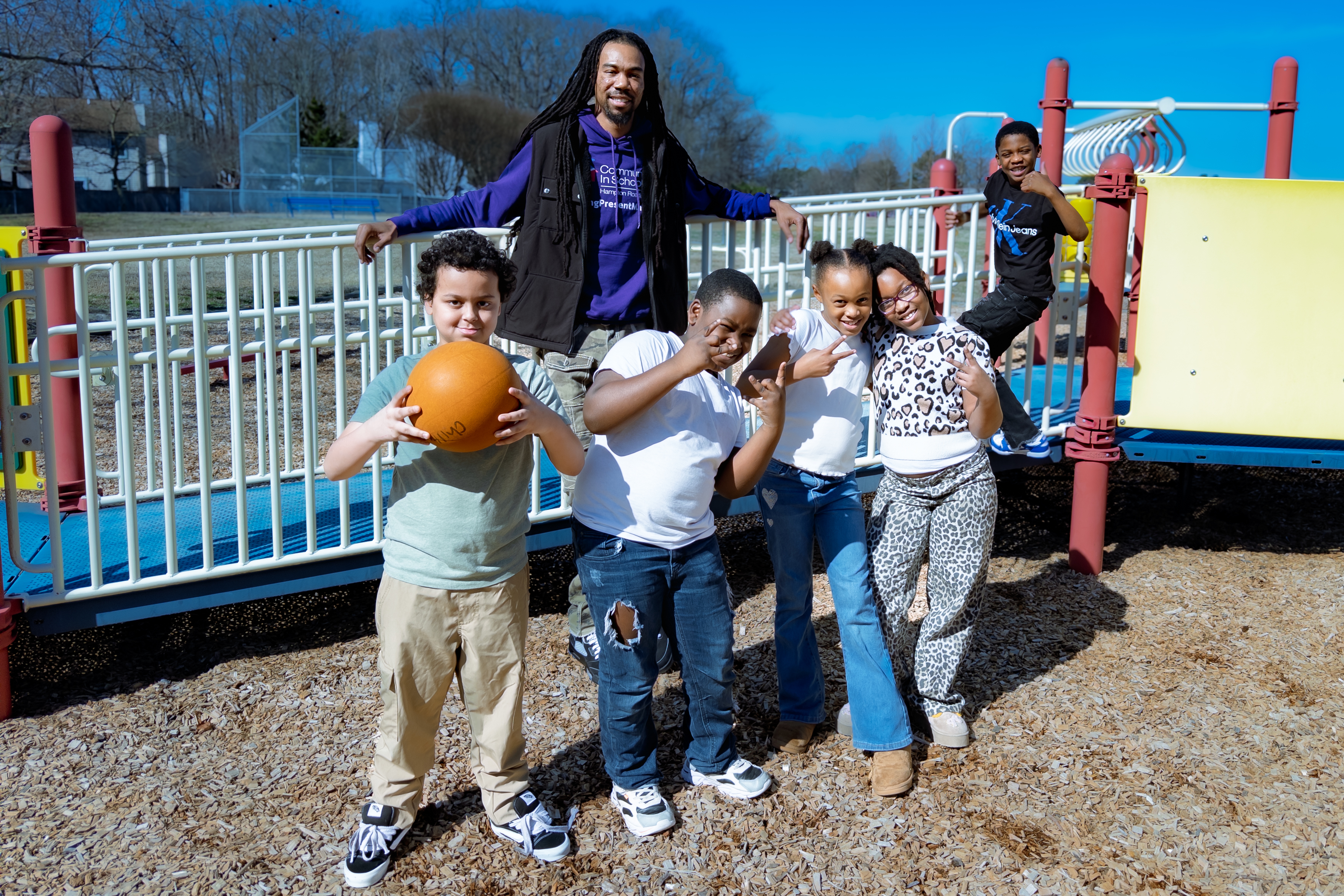 Students with a mentor on the playground, CIS Hampton Roads program