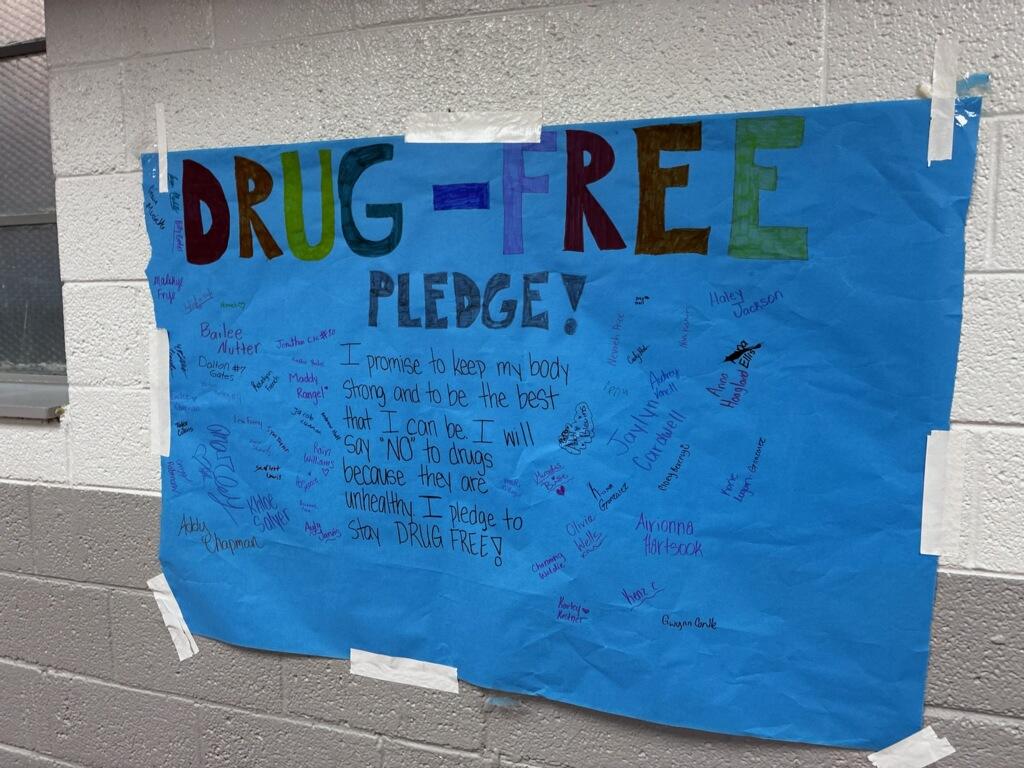 Northwood High School students signing a drug-free pledge displayed in the hallway